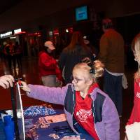 Hunter Rich at GVSU table helping young girl spin prize wheel